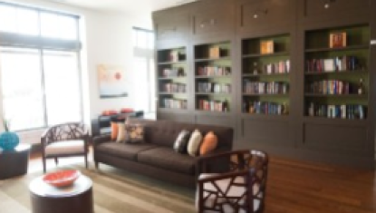 A lobby with wooden furniture and bookshelves